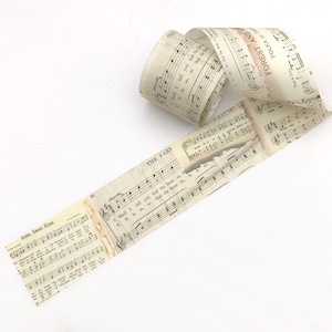 May include: A roll of vintage-style paper tape featuring printed musical notation and lyrics. The paper has a cream-coloured background with black text including titles like Home, Sweet Home, The Farmer, and Forest and Two Polka or Two.