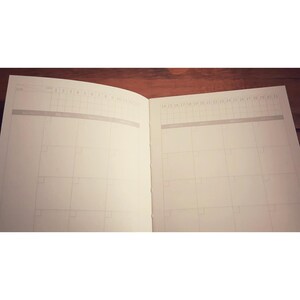 May include: An open planner with two pages showing. The left page has the numbers 1 through 12 at the top. The right page has the numbers 14 through 31 at the top.