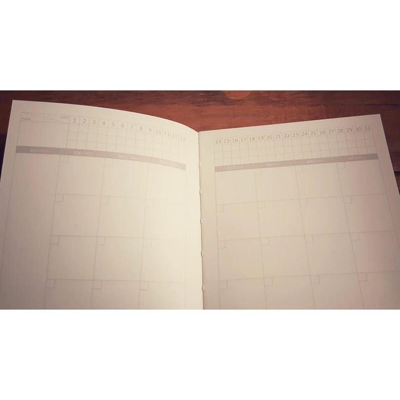 May include: An open planner with two pages showing. The left page has the numbers 1 through 12 at the top. The right page has the numbers 14 through 31 at the top.