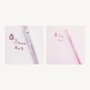 May include: Two clear gel pens with color swatches and text. The pen on the left is brown and says "Brown" and "브라운". The pen on the right is red and says "Red" and "레드".
