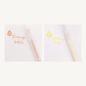 May include: Two clear plastic pens with colored ink. The pen on the left has orange ink and the text "Orange" and "오렌지" written in orange. The pen on the right has yellow ink and the text "Yellow" and "노랑" written in yellow.