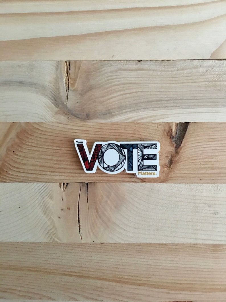 May include: A white sticker with the word "VOTE" in black, red, and gray stylized lettering. The text "Your" appears above the word "VOTE" and the text "Matters." appears below the word "VOTE".