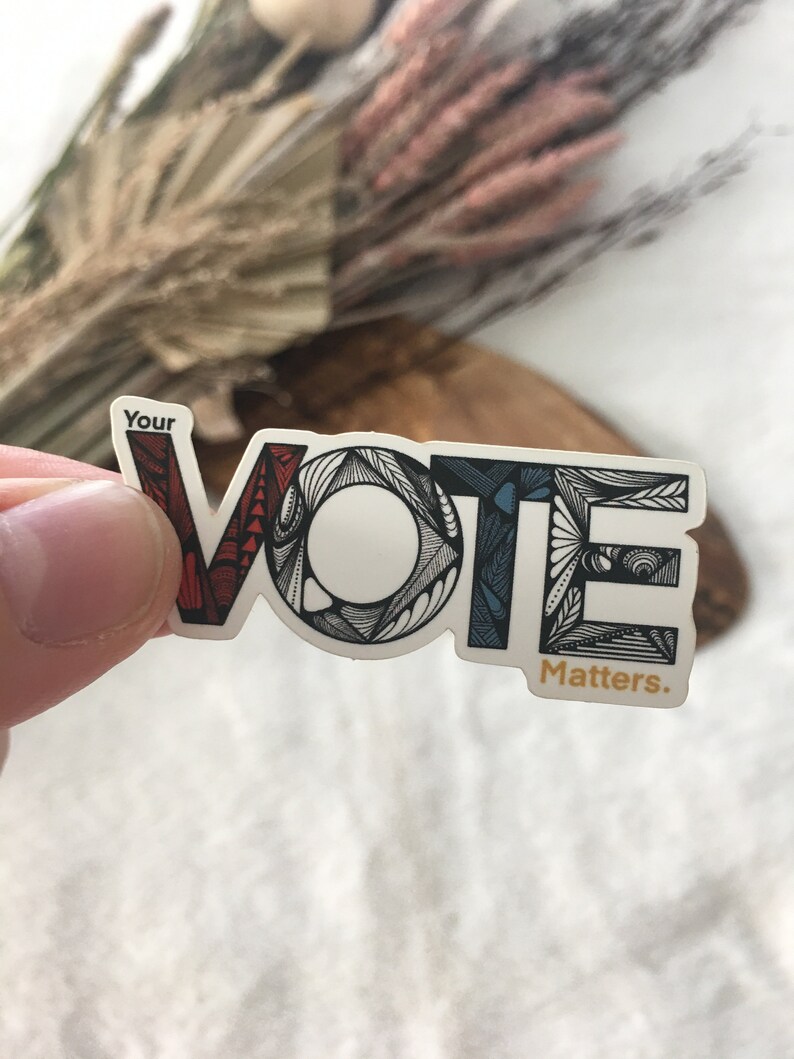 May include: A sticker with the word "VOTE" in stylized lettering. The letters are outlined in black and filled with red, white, and blue. The text "Your" appears above the word "VOTE" and the text "Matters." appears below the word "VOTE".