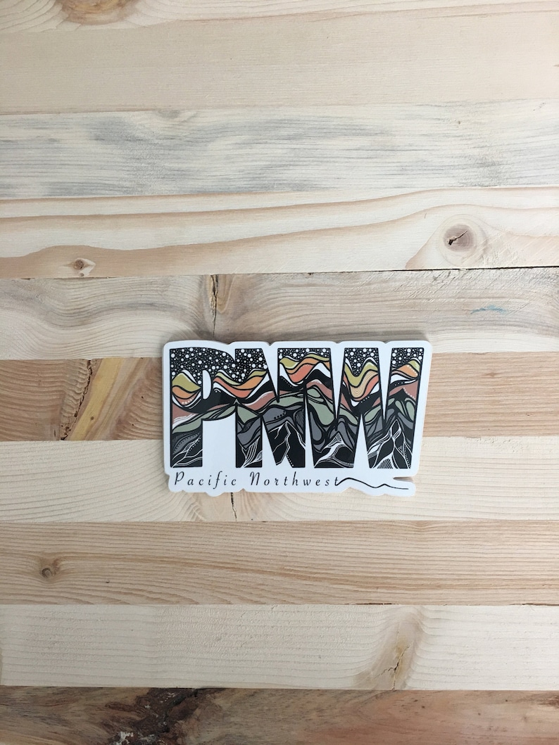 Puede incluir: Una pegatina blanca con un gr&aacute;fico negro, verde, naranja y amarillo de las letras "PNW" con un dise&ntilde;o de cordillera estilizado. El texto "Pacific Northwest" est&aacute; escrito debajo del gr&aacute;fico.