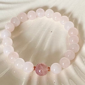 Pu&ograve; includere: Un braccialetto in quarzo rosa con un unico ciondolo di quarzo rosa pi&ugrave; grande al centro. Il braccialetto &egrave; fatto di perline rotonde e lisce.
