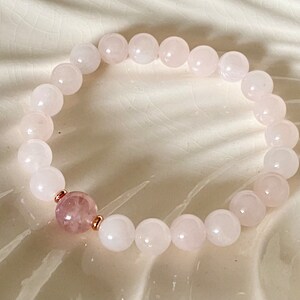 Pu&ograve; includere: Un braccialetto in quarzo rosa con dettagli in oro rosa. Il braccialetto &egrave; fatto di perline rotonde e ha un'unica perla di quarzo rosa pi&ugrave; grande al centro.