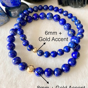 May include: Two circular beaded bracelets made of deep blue lapis lazuli stones. One bracelet features 6mm beads with a gold accent, and the other features 8mm beads with a gold accent. The text 6mm + Gold Accent and 8mm + Gold Accent is visible.