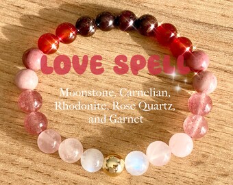 May include: A love spell bracelet with moonstone, carnelian, rhodonite, rose quartz, and garnet beads. The bracelet has a gold accent bead.