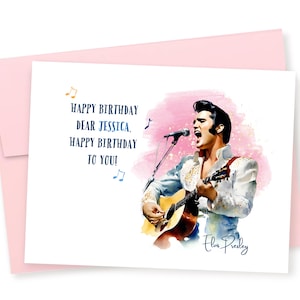 May include: A white card with a pink watercolor background featuring a portrait of Elvis Presley singing and playing a guitar. The text on the card reads "Happy Birthday Dear Jessica, Happy Birthday To You!" and "Elvis Presley" is signed in the bottom right corner.