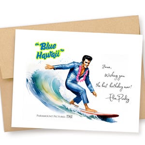 May include: A birthday card featuring Elvis Presley surfing a wave, with the words "Blue Hawaii" in a stylized font. The card includes a birthday message and signature. The Paramount Pictures logo and the year 1961 are also visible.