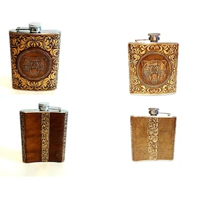 May include: Four different styles of brown leather-covered stainless steel hip flasks. Each flask has a different design, including a bear head, a floral pattern, and a vertical stripe pattern.