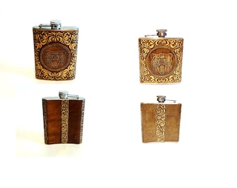 May include: Four different styles of brown leather-covered stainless steel hip flasks. Each flask has a different design, including a bear head, a floral pattern, and a vertical stripe pattern.