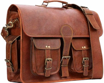 May include: A brown leather briefcase with two large front pockets and a buckle closure. The bag has a top handle and an adjustable shoulder strap.