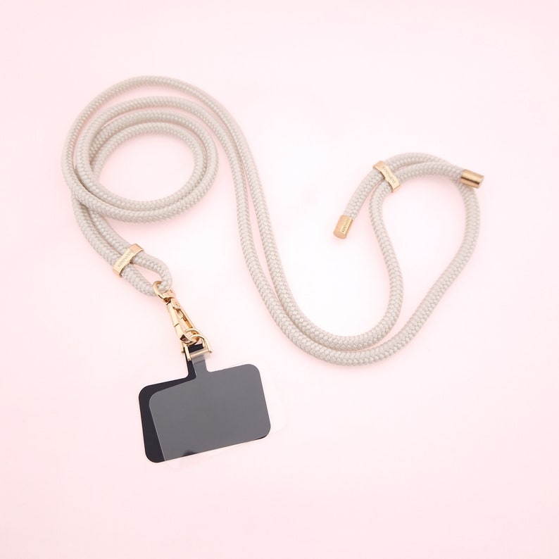 Universal Handykette Pearly in stilvollem Off-White mit Patch, das deine Handyhülle ruckzuck in eine Handykette verwandelt. Mit unserem Adapter kannst du sie an jeder normalen Handyhülle befestigen – ganz ohne lästige Ringe oder Ösen!