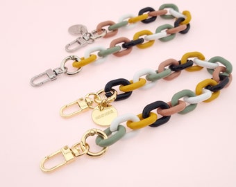 May include: Two colorful chain keychains with gold clasps and a small round tag that says "NEENAA." The chains are made of thick, colorful plastic links in shades of white, black, yellow, green, and brown.