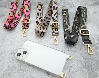May include: Five different phone straps with leopard print patterns. The straps are made of fabric and have gold metal clasps.