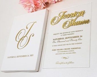 May include: Elegant wedding invitation set featuring gold script on white cardstock. The invitation includes the names "Jessica and Shawn" and the date "Saturday, September 24, 2021". Pink flowers are in the background.