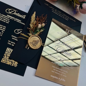 K&ouml;nnte beinhalten: Goldene und schwarze Hochzeitseinladung mit einem goldenen Siegel aus Wachs und einer goldenen Spiegel-Einladung mit dem Text "Jennifer Chante" und "Samstag, 01. November 2025" und "The Handlery Hotel, 950 Hotel Cir. N., San Diego, CA 92108" und "Empfang folgt".