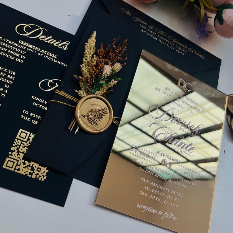 K&ouml;nnte beinhalten: Goldene und schwarze Hochzeitseinladung mit einem goldenen Siegel aus Wachs und einer goldenen Spiegel-Einladung mit dem Text "Jennifer Chante" und "Samstag, 01. November 2025" und "The Handlery Hotel, 950 Hotel Cir. N., San Diego, CA 92108" und "Empfang folgt".