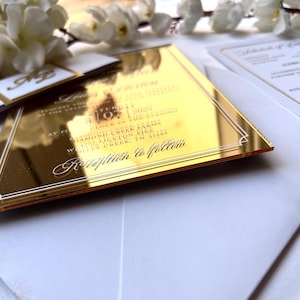 K&ouml;nnte beinhalten: Goldene Spiegel-Hochzeitseinladung mit wei&szlig;em Text. Die Einladung enth&auml;lt Datum, Uhrzeit und Ort der Hochzeitszeremonie und des Empfangs. Der Text lautet "Samstag, 10. September 2023 um 17:00 Uhr, Diamond Creek Farms, 14725 Lickton Pike, Whites Creek, TN 37189. Empfang im Anschluss."