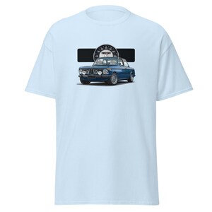 Peut inclure: T-shirt bleu clair avec une illustration d'une voiture bleue classique et un compteur de vitesse. La voiture est représentée avec des détails précis. Le t-shirt est conçu pour un usage décontracté, offrant un confort quotidien.