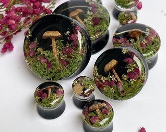 Jauges naturelles de mousse, de fleurs et de champignons avec fond noir, vrai bouchon, bouchon champignon, vrais bouchons champignon, tunnels champignon.