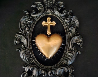 Framed golden sacred heart with gold cross, gothic art. Mounted on black velvet in a black hand cast ornate frame.