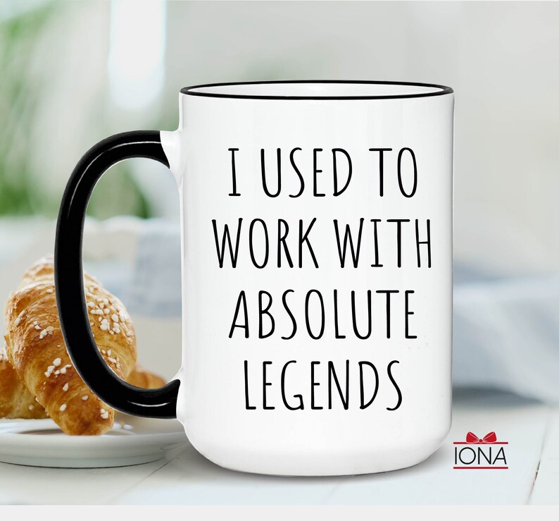 Peut inclure: Mug en c&eacute;ramique blanche avec une anse et un bord noirs. Le mug porte une inscription noire qui dit "J'ai travaill&eacute; avec des l&eacute;gendes absolues".