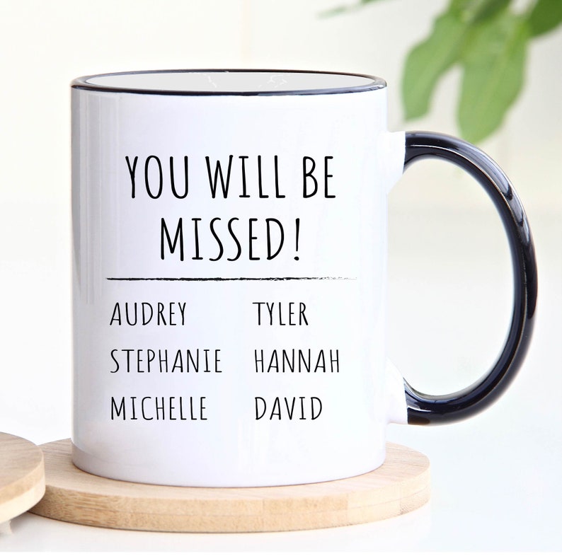 Peut inclure: Une tasse &agrave; caf&eacute; en c&eacute;ramique blanche avec un bord et une poign&eacute;e noirs. La tasse porte le texte "You will be missed!" avec une ligne en dessous. Sous la ligne se trouvent les noms Audrey, Stephanie, Michelle, Tyler, Hannah et David.