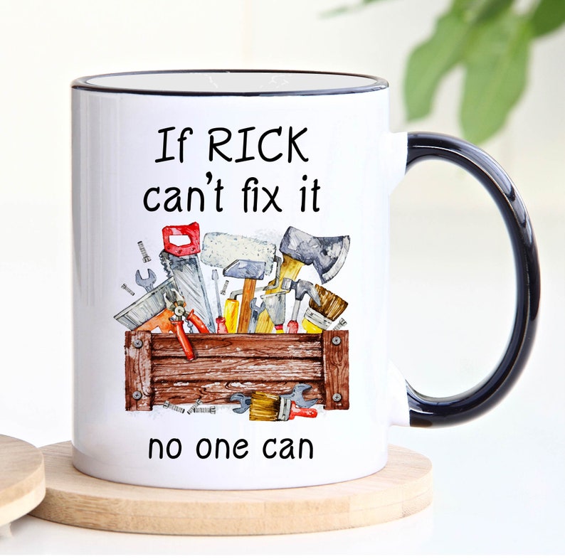 May include: White ceramic mug with a black handle and rim. The mug features a watercolor illustration of a toolbox filled with tools. Text on the mug reads "If RICK can't fix it, no one can."