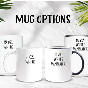 Op de afbeelding: Vier witte keramische mokken met zwarte letters. De mokken zijn verkrijgbaar in twee maten: 11 ounce en 15 ounce. De 15 ounce mokken zijn verkrijgbaar in wit of wit met een zwarte rand en handvat.