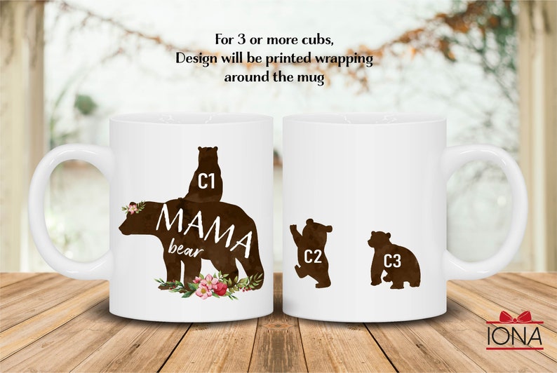 May include: White ceramic mug with a brown silhouette of a mama bear and three cubs. The mama bear has the text "MAMA bear" on her back. The cubs are numbered C1, C2, and C3. The mug has a floral design at the bottom.