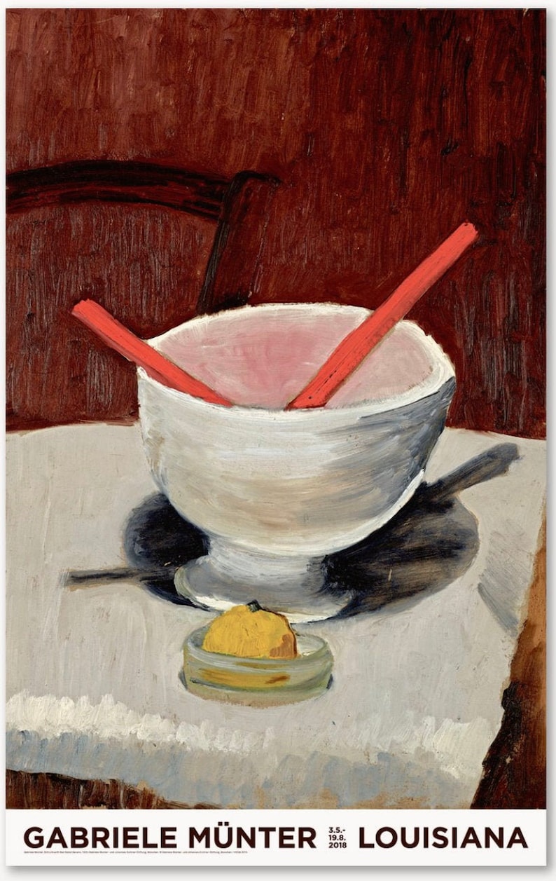 May include: A white bowl with a pink interior and two red chopsticks inside, sitting on a white tablecloth with a yellow lemon in a glass dish. The bowl is on a table with a dark brown background.