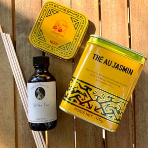 May include: An assortment of tea and home fragrance products. Includes a yellow tin of "Thé au Jasmin" tea, a small bottle of "White Tea" reed diffuser, a yellow tin of tea, and reed diffuser sticks. The tea tin weighs 120g.