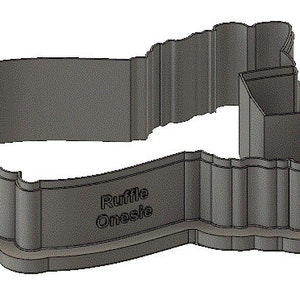 Peut inclure: Emporte-pi&egrave;ce en plastique gris en forme de grenouill&egrave;re avec les mots "Ruffle Onesie" en bas.