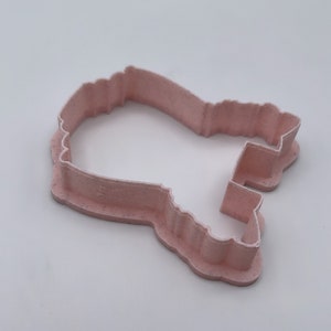 Peut inclure: Un emporte-pi&egrave;ce en plastique rose en forme de fant&ocirc;me de dessin anim&eacute;. L'emporte-pi&egrave;ce a un design d&eacute;taill&eacute; avec un bord ondul&eacute; et un petit trou en haut.