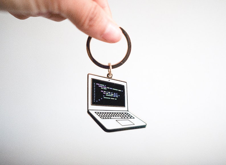 Peut inclure: Un porte-cl&eacute;s argent&eacute; avec un charme en forme d'ordinateur portable. L'ordinateur portable a un &eacute;cran noir avec du code color&eacute; dessus.