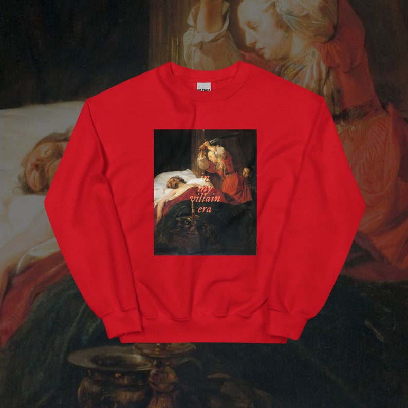May include: Red sweatshirt with a painting of a woman holding a knife over a man lying in bed. The text "my villain era" is printed on the sweatshirt.