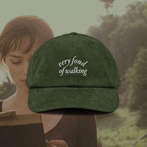 以下が含まれることがあります： 「very fond of walking」と白く刺繍された緑色のコーデュロイ製のベースボールキャップです。