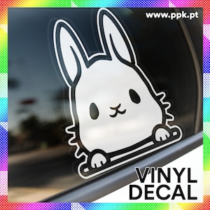 Puede incluir: Calcomanía de vinilo en blanco y negro de un conejo de dibujos animados con orejas grandes y una cara linda. La calcomanía está en la ventana de un automóvil y dice "VINYL DECAL" en la parte inferior.