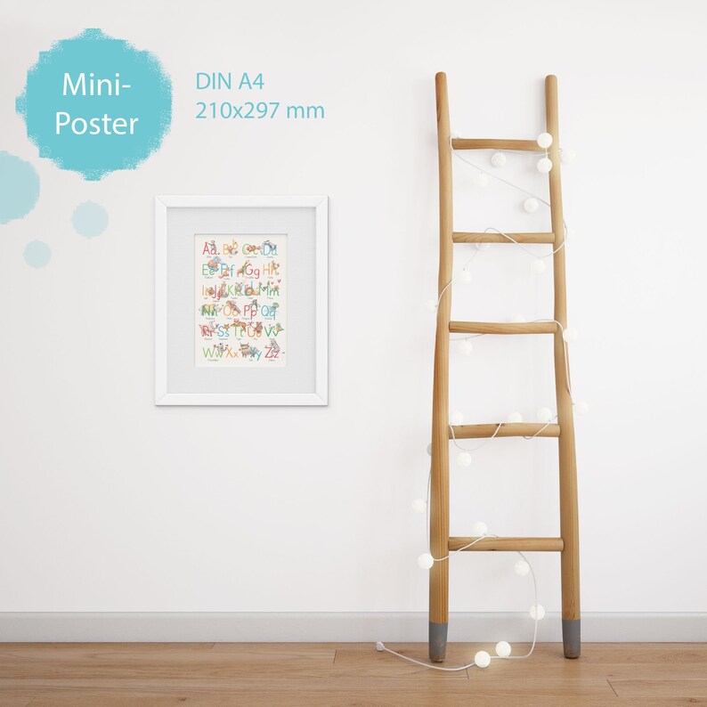 May include: A white framed poster with a colorful alphabet print. The poster is labeled "Mini-Poster" and "DIN A4 210x297 mm". The poster is hanging on a white wall next to a wooden ladder with white string lights.
