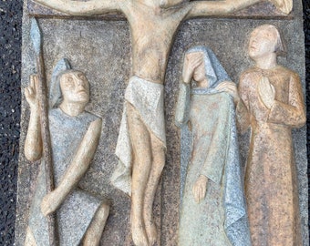 May include: A stone relief sculpture depicting the crucifixion of Jesus Christ. The sculpture shows Jesus on the cross with a soldier holding a spear, a woman weeping, and a man praying.
