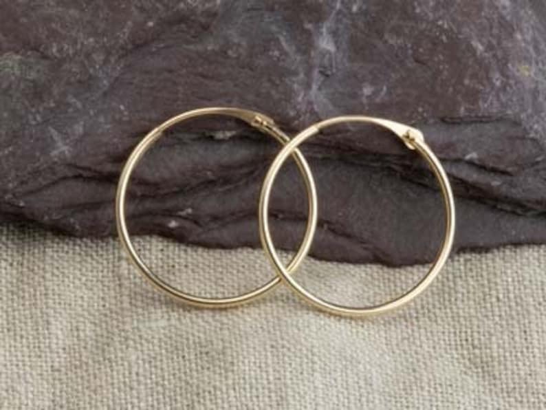 May include: A pair of gold hoop earrings. The earrings are simple and classic, and they would make a great gift for any occasion.