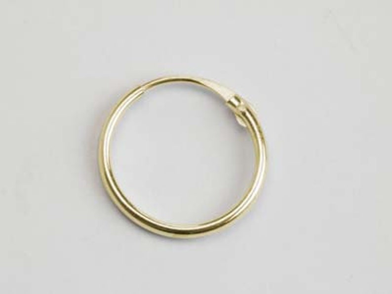 May include: A gold hoop earring with a smooth, polished finish.