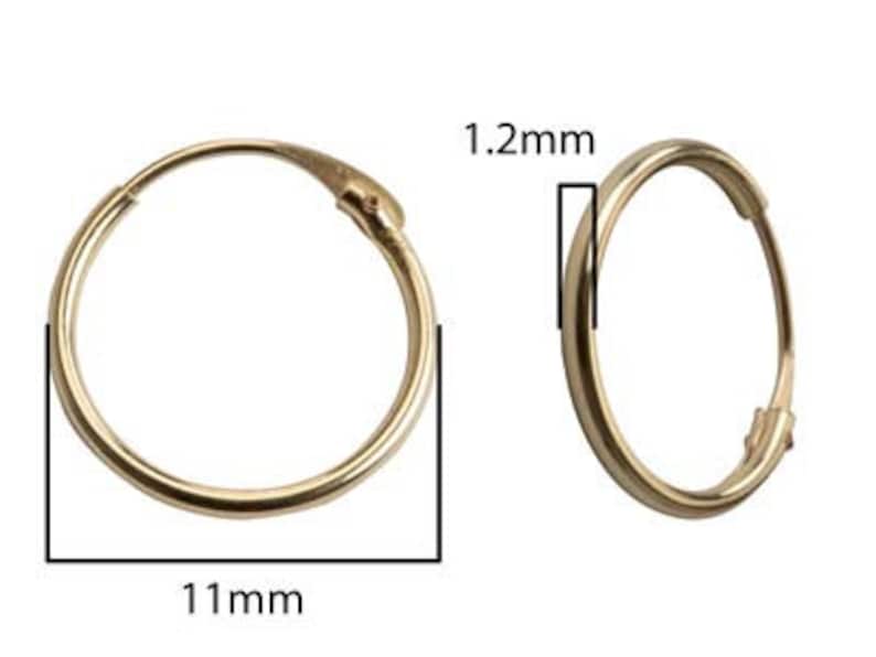 May include: A pair of gold hoop earrings, 11 mm in diameter and 1.2 mm thick.