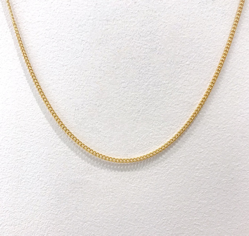 May include: A gold chain necklace with a delicate, fine link design.