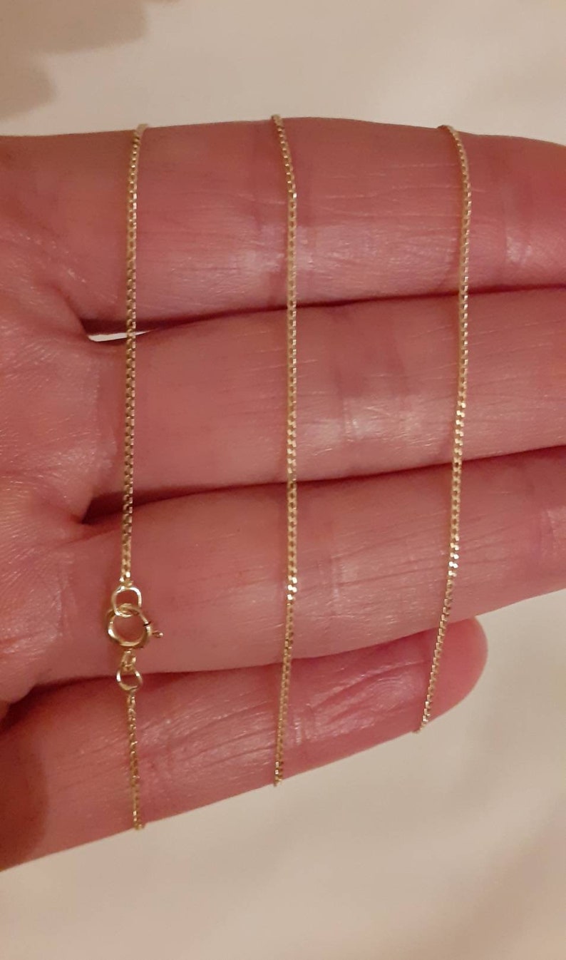 May include: A gold chain necklace with a lobster clasp closure.