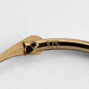 May include: Close-up of a gold hoop earring with a clasp. The earring is marked with the number "375".