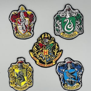 May include: Set of four embroidered iron-on patches featuring the Hogwarts house crests: Gryffindor, Slytherin, Hufflepuff, and Ravenclaw. Each patch features the house mascot, colors, and motto.
