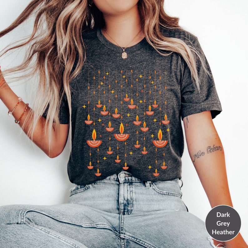 A woman wearing a grey shirt with candles on it
